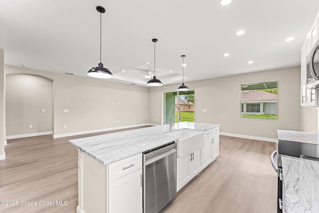 kitchen featuring appliances with stainless steel finishes, light wood-style floors, a sink, white cabinets, and recessed lighting