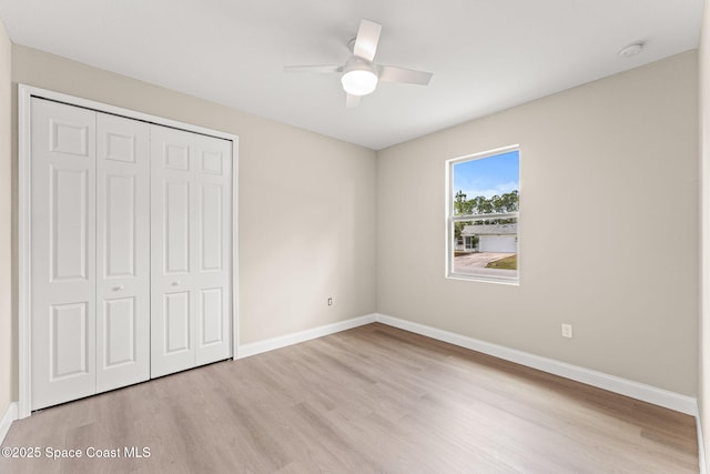 unfurnished bedroom with light wood finished floors, a closet, and baseboards