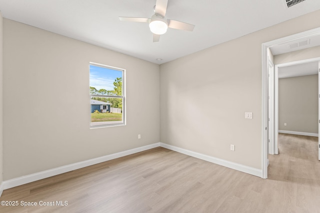 spare room featuring light wood-style flooring, baseboards, and ceiling fan