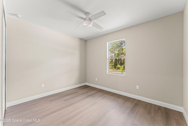 unfurnished room featuring a ceiling fan, light wood-style floors, baseboards, and a smoke detector
