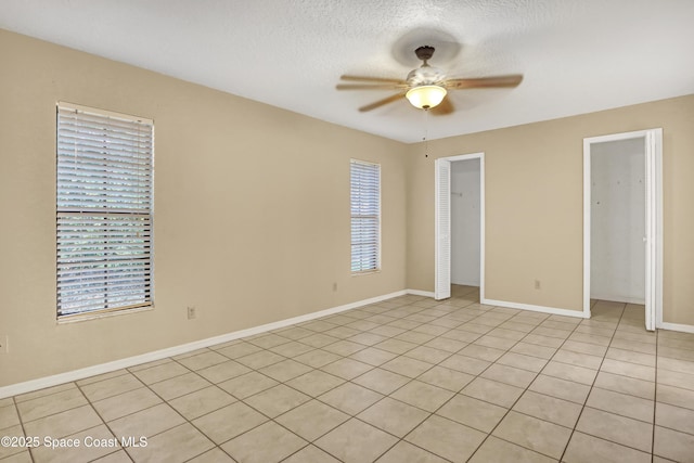 690 Koutnik Rd SE, Palm Bay, FL 32909 - unfurnished bedroom featuring light tile patterned flooring, ceiling fan, baseboards, and a textured ceiling