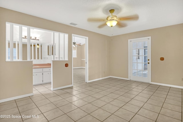 690 Koutnik Rd SE, Palm Bay, FL 32909 - empty room with a ceiling fan, light tile patterned flooring, healthy amount of natural light, and baseboards