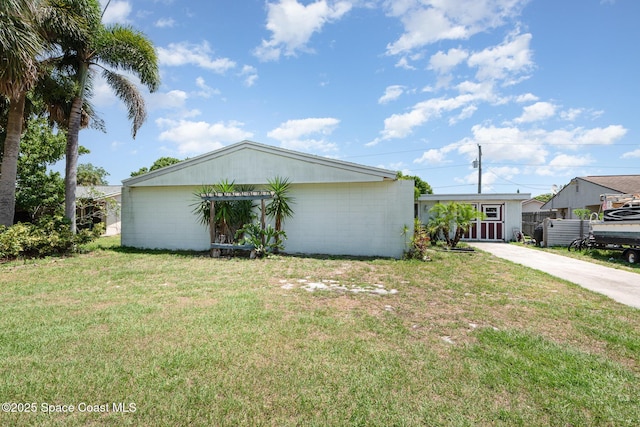 958 Beaumont Ln, Rockledge, FL 32955 - view of side of property with concrete driveway, a lawn, and concrete block siding