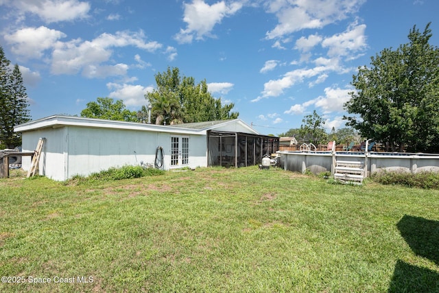 958 Beaumont Ln, Rockledge, FL 32955 - rear view of house featuring a sunroom, french doors, and a yard