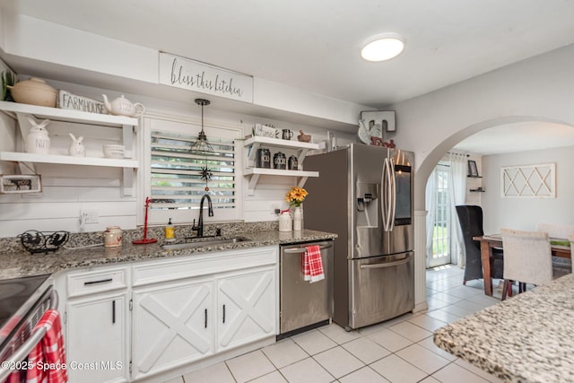 958 Beaumont Ln, Rockledge, FL 32955 - kitchen featuring appliances with stainless steel finishes, open shelves, a sink, arched walkways, and light tile patterned flooring
