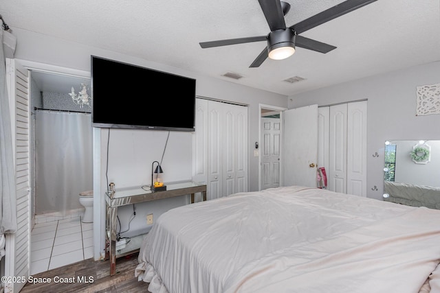 958 Beaumont Ln, Rockledge, FL 32955 - bedroom with multiple closets, wood finished floors, ceiling fan, a textured ceiling, and ensuite bath