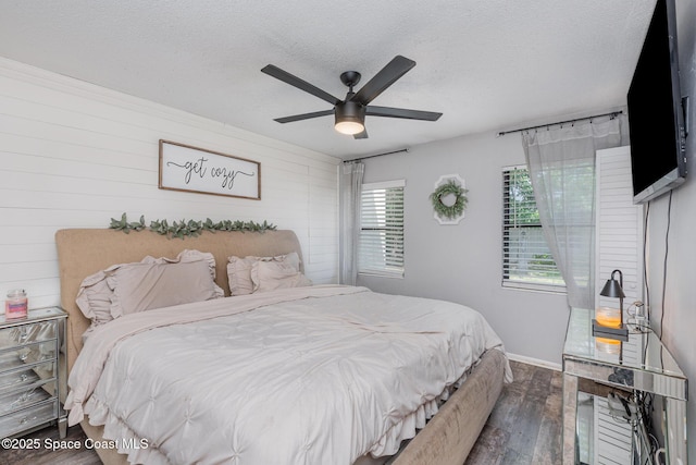 958 Beaumont Ln, Rockledge, FL 32955 - bedroom featuring wood-type flooring, a textured ceiling, baseboards, a ceiling fan, and wooden walls