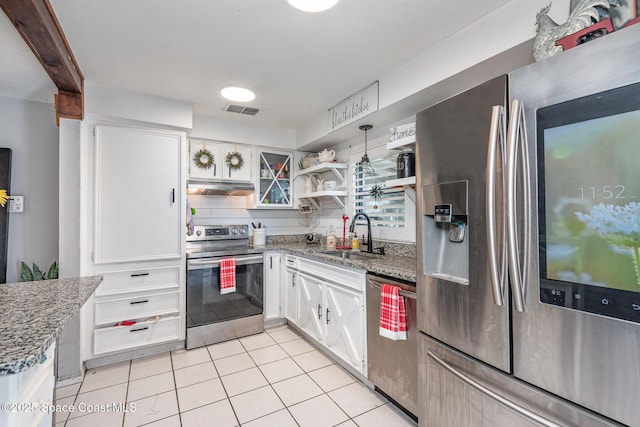 958 Beaumont Ln, Rockledge, FL 32955 - kitchen featuring stainless steel appliances, a sink, under cabinet range hood, light tile patterned flooring, and white cabinetry