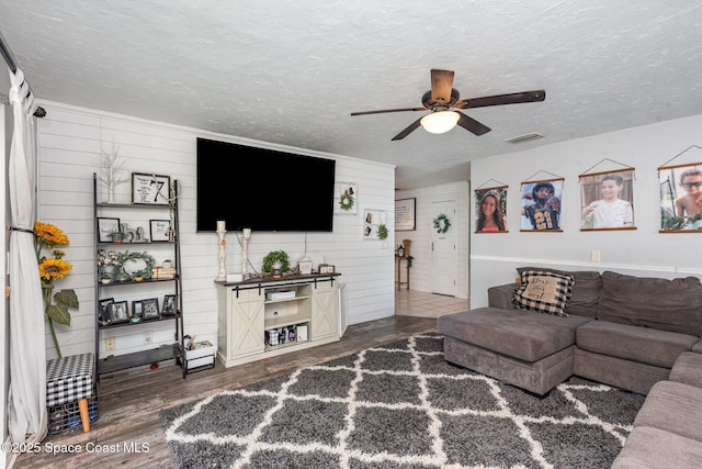 958 Beaumont Ln, Rockledge, FL 32955 - living area with dark wood finished floors, ceiling fan, a textured ceiling, and wood walls