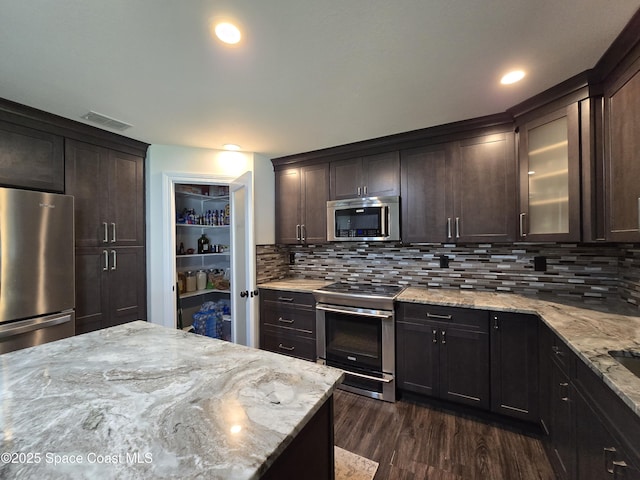 334 Dryden Cir, Cocoa, FL 32926 - kitchen featuring appliances with stainless steel finishes, light stone countertops, dark brown cabinetry, and recessed lighting