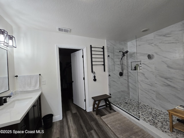 334 Dryden Cir, Cocoa, FL 32926 - bathroom with wood finished floors, walk in shower, a textured ceiling, vanity, and baseboards