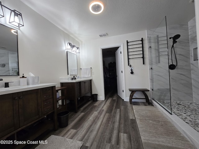 334 Dryden Cir, Cocoa, FL 32926 - full bath featuring a walk in shower, wood finished floors, two vanities, a textured ceiling, and a walk in closet