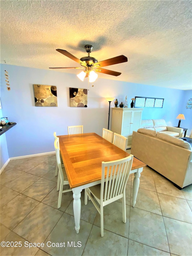 35 Sunflower St Unit 59, Cocoa Beach, FL 32931 - dining room with ceiling fan, a textured ceiling, light tile patterned flooring, and baseboards