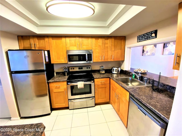 35 Sunflower St Unit 59, Cocoa Beach, FL 32931 - kitchen with stainless steel appliances, a sink, a raised ceiling, and brown cabinetry