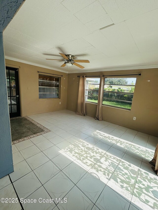 2174 Woodbury Rd, Melbourne, FL 32935 - unfurnished living room featuring ceiling fan, crown molding, and tile patterned flooring