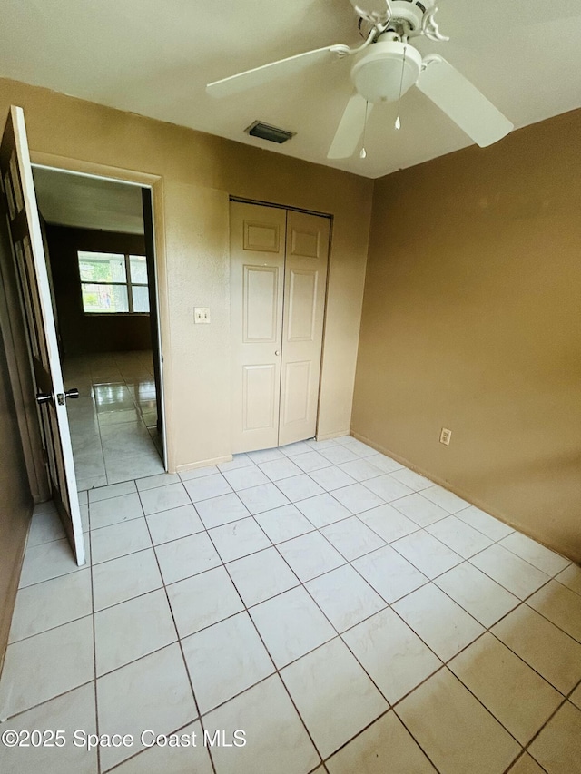 2174 Woodbury Rd, Melbourne, FL 32935 - unfurnished bedroom featuring light tile patterned floors, a closet, and a ceiling fan