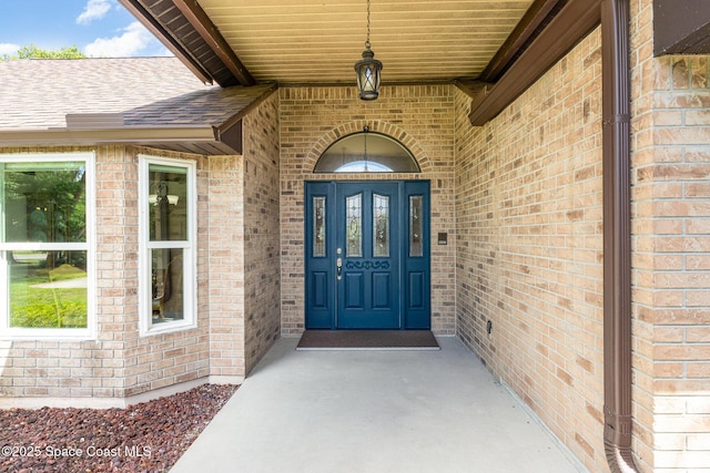7793 Windover Way, Titusville, FL 32780 - view of exterior entry with brick siding and a shingled roof