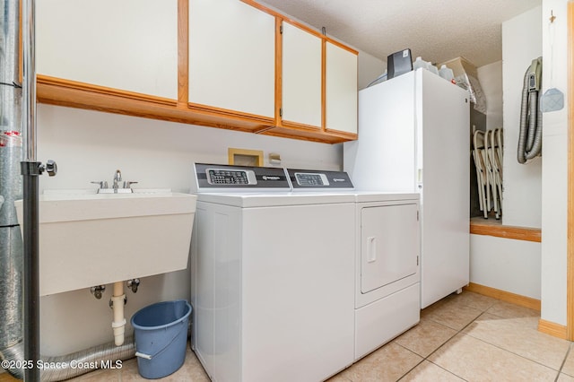 7793 Windover Way, Titusville, FL 32780 - laundry area with cabinet space, separate washer and dryer, light tile patterned floors, and baseboards
