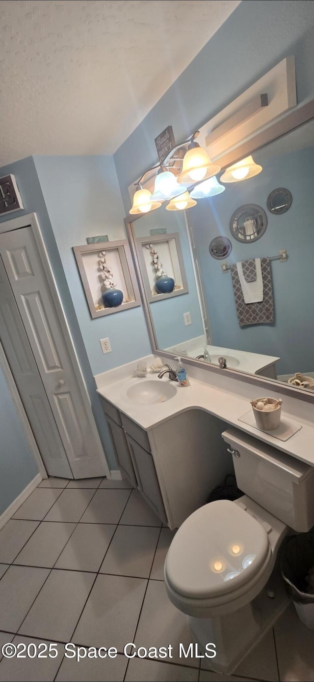 bathroom featuring tile patterned floors, vanity, and toilet