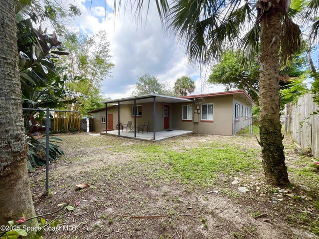 141 Valencia Rd, Rockledge, FL 32955 - rear view of house with stucco siding, a fenced backyard, and a patio