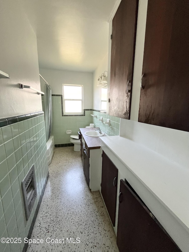 141 Valencia Rd, Rockledge, FL 32955 - bathroom with tile walls, vanity, toilet, wainscoting, and shower / bathtub combination with curtain