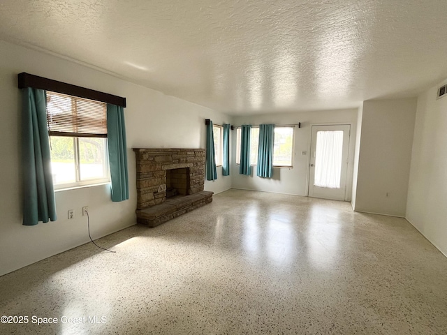 141 Valencia Rd, Rockledge, FL 32955 - unfurnished living room with speckled floor, a fireplace, and a textured ceiling