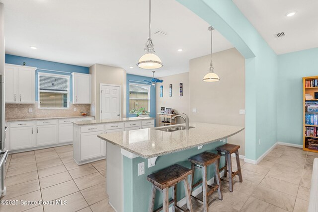 3575 Salt Marsh Cir, West Melbourne, FL 32904 - kitchen with an island with sink, a sink, tasteful backsplash, light tile patterned floors, and recessed lighting