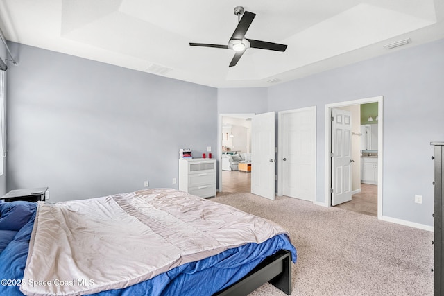 3575 Salt Marsh Cir, West Melbourne, FL 32904 - bedroom with carpet flooring, baseboards, ceiling fan, a tray ceiling, and connected bathroom