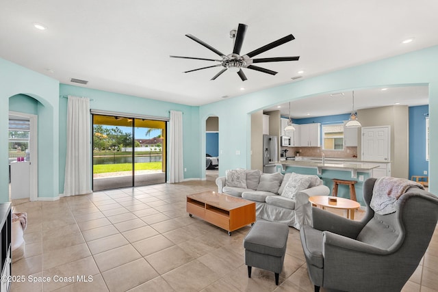 3575 Salt Marsh Cir, West Melbourne, FL 32904 - living area with arched walkways, a ceiling fan, light tile patterned floors, baseboards, and recessed lighting