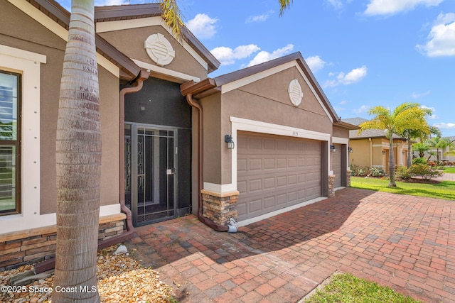 3575 Salt Marsh Cir, West Melbourne, FL 32904 - view of front of home featuring stone siding, a garage, stucco siding, and decorative driveway