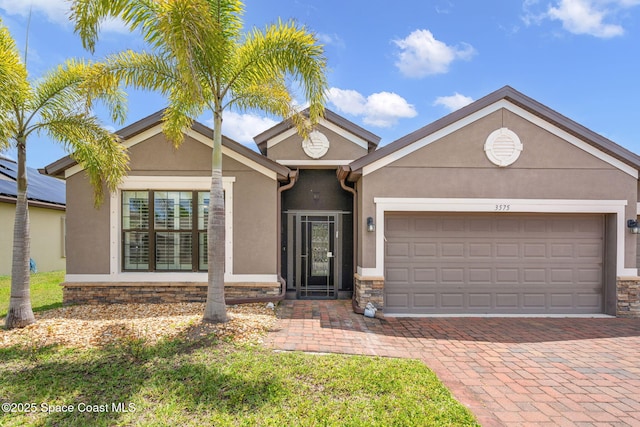 3575 Salt Marsh Cir, West Melbourne, FL 32904 - single story home featuring stucco siding, an attached garage, decorative driveway, and stone siding