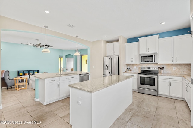 3575 Salt Marsh Cir, West Melbourne, FL 32904 - kitchen with appliances with stainless steel finishes, a center island with sink, a sink, backsplash, and decorative light fixtures