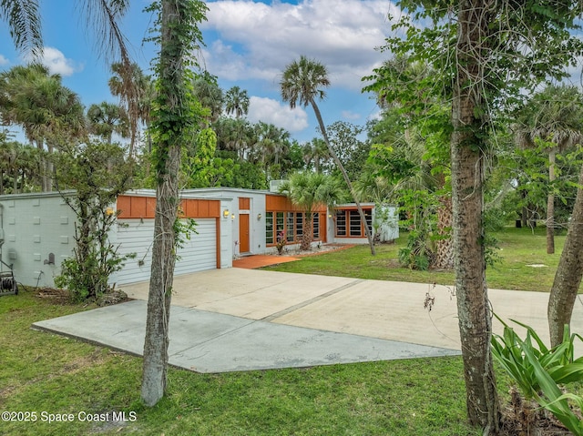 2318 Country Club Rd, Melbourne, FL 32901 - mid-century modern home featuring concrete driveway, a front lawn, and a garage