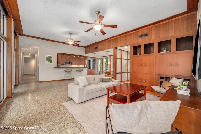 2318 Country Club Rd, Melbourne, FL 32901 - living room featuring baseboards, ornamental molding, ceiling fan, wooden walls, and dark speckled floor