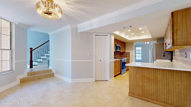 2287 Venetia Pl, Indialantic, FL 32903 - kitchen featuring stainless steel appliances, backsplash, brown cabinets, light countertops, and crown molding