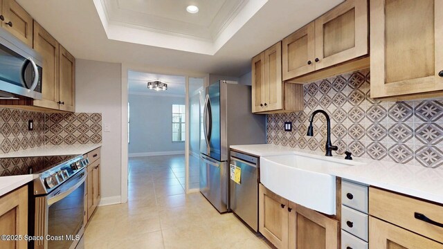2287 Venetia Pl, Indialantic, FL 32903 - kitchen with stainless steel appliances, a raised ceiling, backsplash, light tile patterned floors, and light countertops