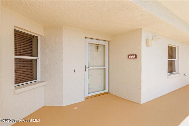 7008 Sevilla Ct Ph 505, Cape Canaveral, FL 32920 - view of exterior entry with stucco siding and a patio