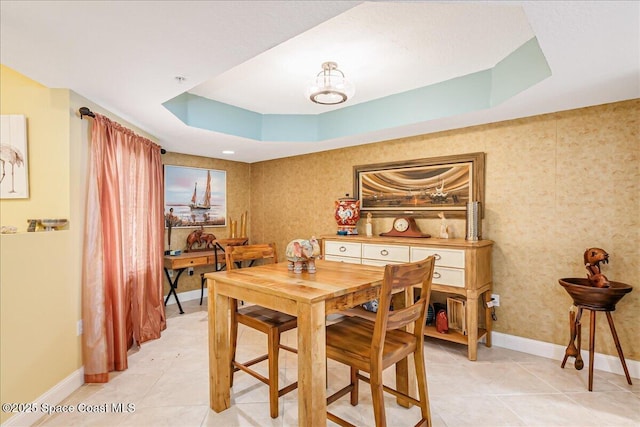 7008 Sevilla Ct Ph 505, Cape Canaveral, FL 32920 - dining space featuring a raised ceiling, baseboards, light tile patterned floors, and wallpapered walls