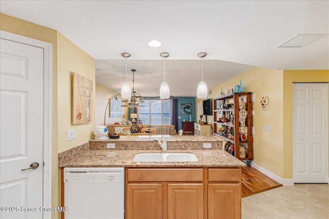 7008 Sevilla Ct Ph 505, Cape Canaveral, FL 32920 - kitchen featuring white dishwasher, a sink, a peninsula, light stone counters, and decorative light fixtures