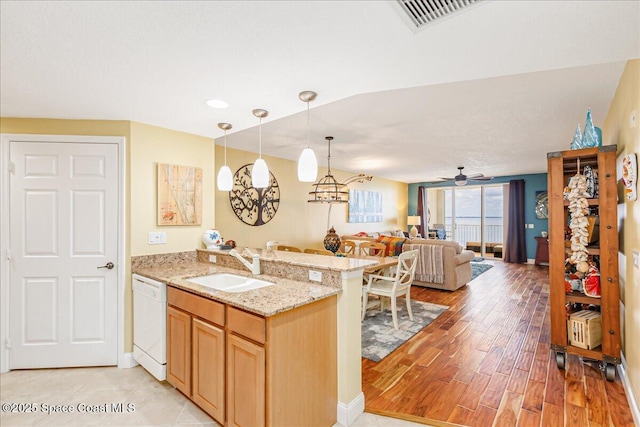 7008 Sevilla Ct Ph 505, Cape Canaveral, FL 32920 - kitchen featuring dishwasher, a sink, open floor plan, light wood-style flooring, and decorative light fixtures