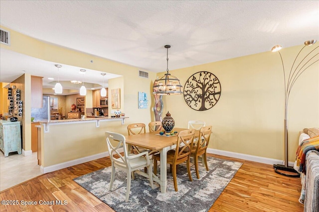 7008 Sevilla Ct Ph 505, Cape Canaveral, FL 32920 - dining room featuring light wood-style floors, a chandelier, and baseboards