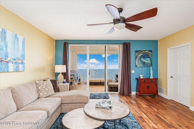 7008 Sevilla Ct Ph 505, Cape Canaveral, FL 32920 - living room featuring ceiling fan, wood finished floors, a textured ceiling, and baseboards