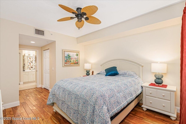 7008 Sevilla Ct Ph 505, Cape Canaveral, FL 32920 - bedroom featuring wood finished floors, baseboards, ceiling fan, and ensuite bathroom