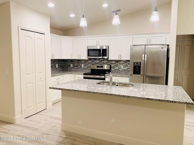 kitchen featuring stainless steel appliances, a sink, tasteful backsplash, white cabinets, and pendant lighting