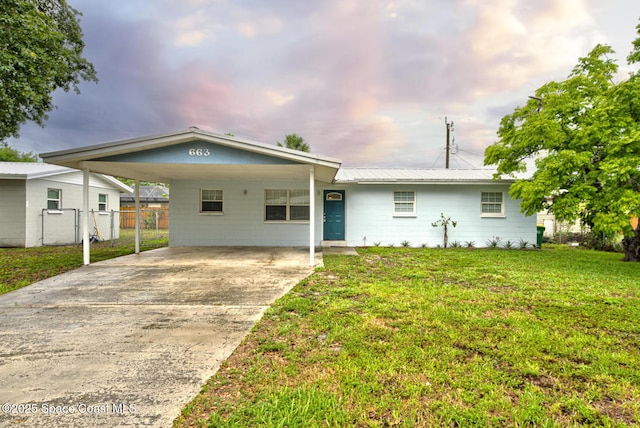 663 Bacon St, Cocoa, FL 32926 - ranch-style house with driveway, an attached carport, and metal roof