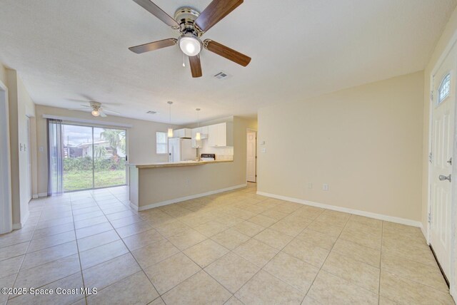 663 Bacon St, Cocoa, FL 32926 - unfurnished living room featuring light tile patterned floors, healthy amount of natural light, ceiling fan, and baseboards
