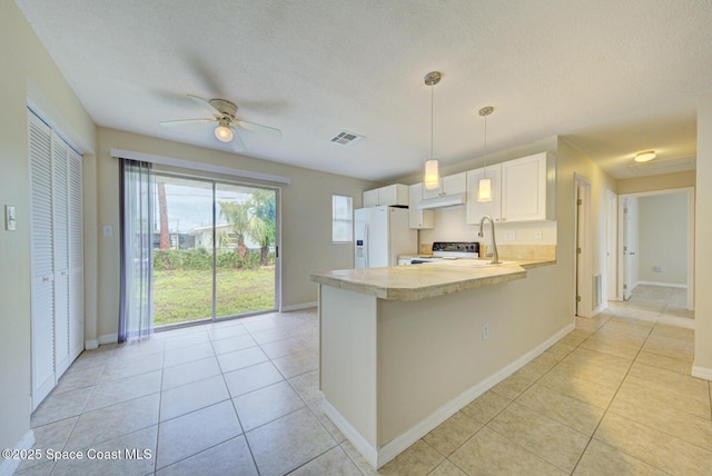 663 Bacon St, Cocoa, FL 32926 - kitchen featuring white fridge with ice dispenser, a peninsula, light countertops, baseboards, and electric range oven