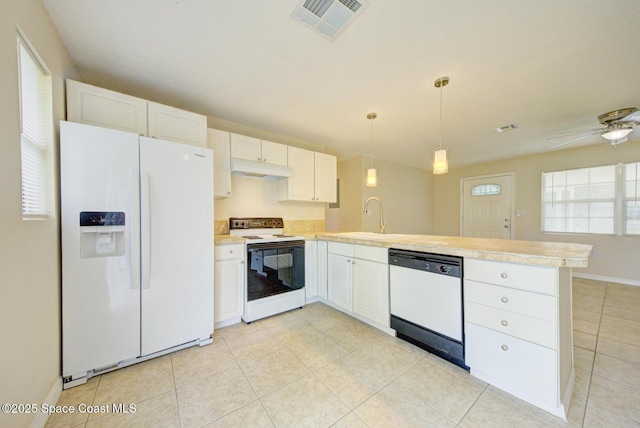 663 Bacon St, Cocoa, FL 32926 - kitchen with white appliances, a peninsula, a sink, light countertops, and white cabinets