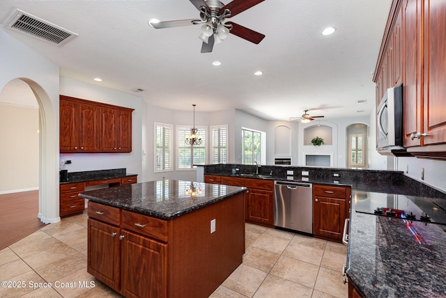 kitchen with appliances with stainless steel finishes, a ceiling fan, a sink, arched walkways, and recessed lighting