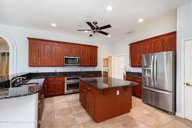 kitchen featuring appliances with stainless steel finishes, a sink, a ceiling fan, a kitchen island, and recessed lighting
